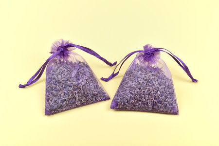 Fragrant bag filled with dried lavender flowers on the yellow background. Top view.の写真素材