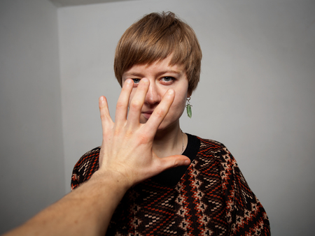 man's hand is straching to the woman's faceの写真素材