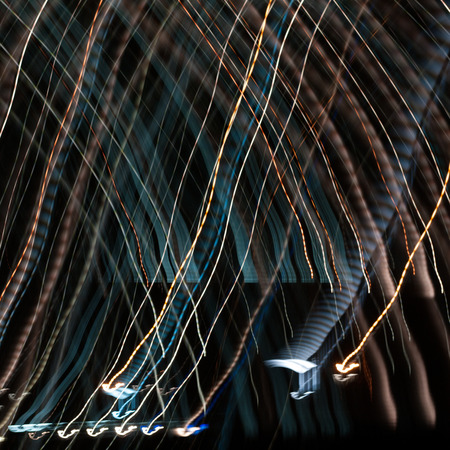 Fire colored stripes on a dark background. Abstract blurred out of focus image of the city at night.