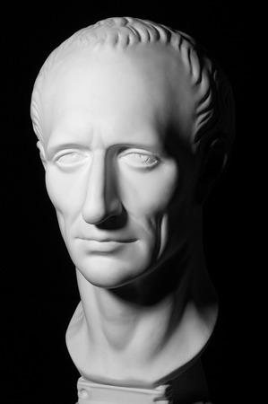 White gypseous head of a man isolated on black backgroundの写真素材