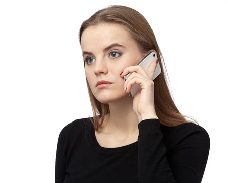 Brown - haired woman in a black dress is talking on the cellphone. Close up, isolated on white backgroundの写真素材