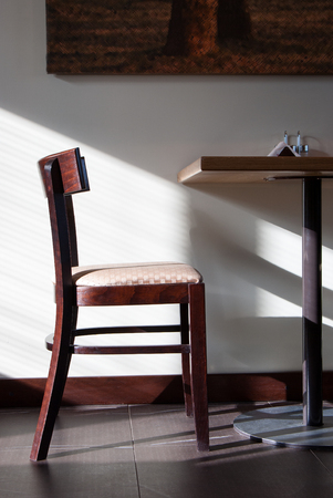 Wooden chair and table in the cafe litted by the sunlightの写真素材