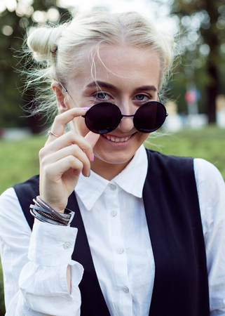 Close up portrait of a trendy young woman in sunglasses in the city parkの写真素材