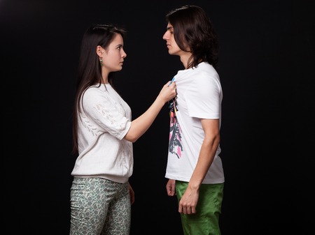Family quarrel - woman is threatening the man, black background