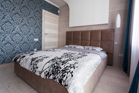 Bed in a modern bedroom in brown and blue tones
