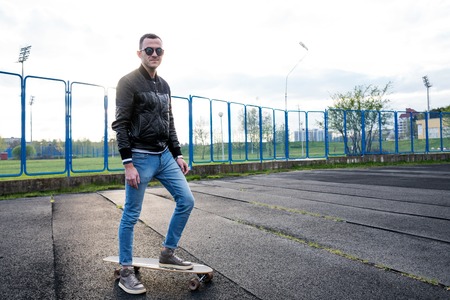Young hipster man with a long board outdoors