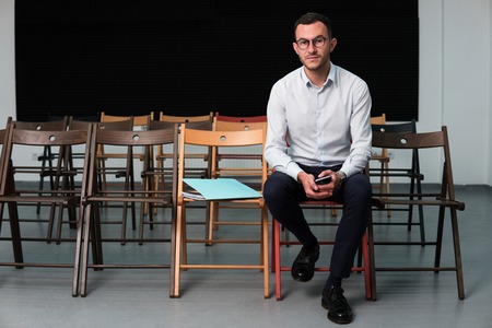 Young successful businessman man sitting on chair in training roomの写真素材