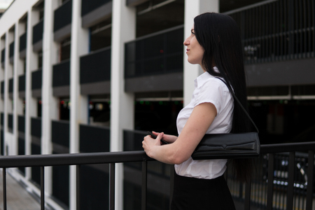 Successful business woman looks aside in cityの写真素材
