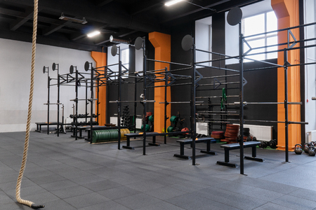 Interior of the gym for fitness workout with horizontal bar, barbells and ropeの写真素材