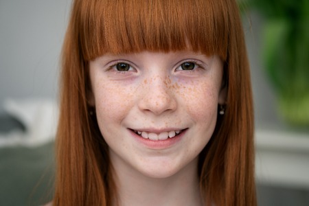 Happy little ginger girl with freckles smilingの写真素材