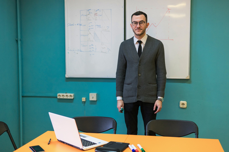 Man teacher standing near whiteboard in university classroomの写真素材