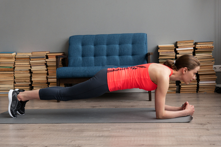 Fitness woman doing plank exercise on mat at homeの写真素材