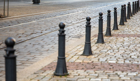 Black posts separating paved street and path