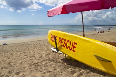 Yellow surf rescue board on the beach under red umbrella のeditorial素材