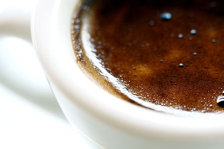 white espresso cup & saucer filled with coffee beansの写真素材