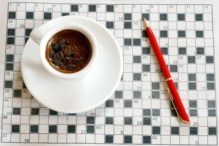 a cup of coffee with crossword in backgroundの写真素材
