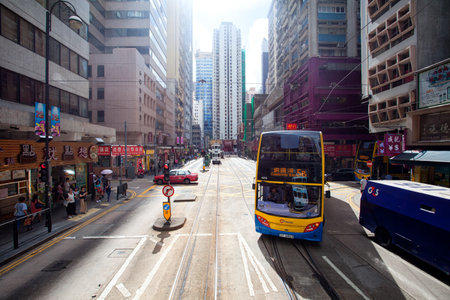 HONG KONG - JULY 18, 2017: Electric trolley and motor vehicle on a typical downtown street in Hong Kong, Chinaのeditorial素材