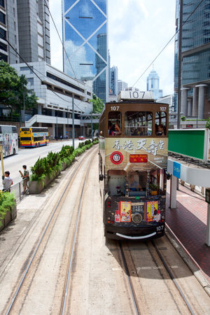 HONG KONG - JULY 18, 2017: Electric trolley and motor vehicle on a typical downtown street in Hong Kong, Chinaのeditorial素材