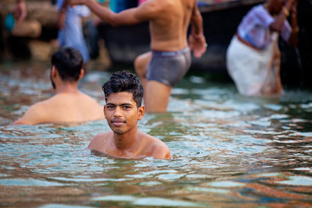 VARANASI, UTTAR PRADESH, INDIA - JULY 7 2018: Pilgrims bathing and performing the holy water. Ganges river in the early morningのeditorial素材