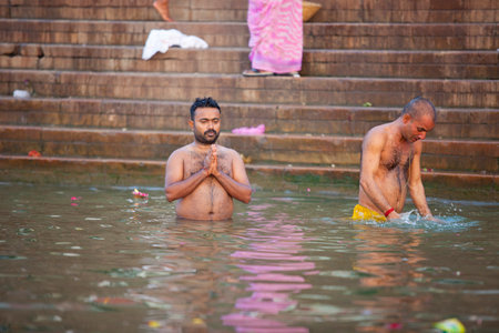 VARANASI, UTTAR PRADESH, INDIA - JULY 7 2018: Pilgrims bathing and performing the holy water. Ganges river in the early morningのeditorial素材