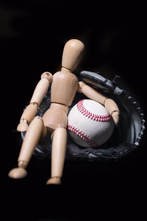 baseball concept with ball glove and wooden doll