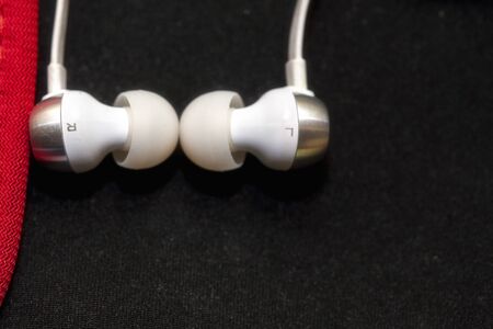 White Headphones for ears. On a black background