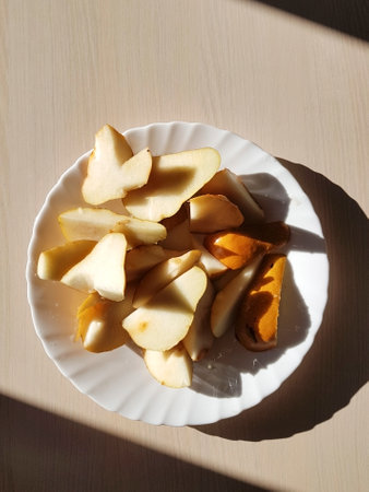 Sliced ââpears on a white plate. Top to bottom view. Illuminated by a sharp light.の写真素材