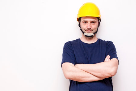 Constraction worker behind white background. Wearing green mask and yellow helmet.の写真素材