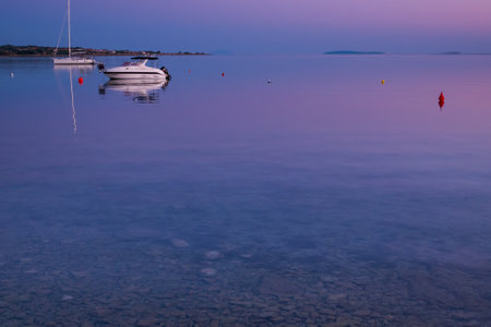 Sea view on island Vir, Croatia early in the morning. Two white boats overlooking beautiful purple and pink sky over Adriatic sea.の写真素材
