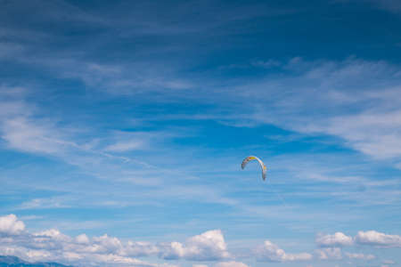 Parachute of the kitesurfer against blue sky. Clouds on the sky.