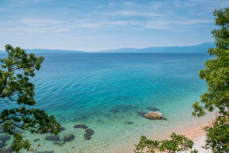 Blue and green sea, beautiful beach and green trees in Kostrena, Croatia.の写真素材