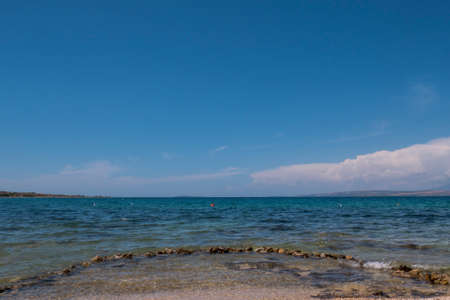 Beautiful coast, blue sea and mountains in the distance. Nice view of the blue Adriatic sea during a sunny day.の写真素材