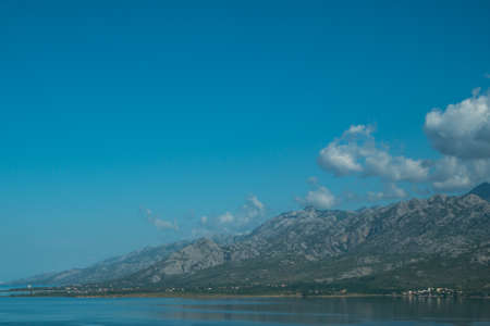 Beautiful coast, blue sea and mountains in the distance. Nice view of the blue Adriatic sea during a sunny day.の写真素材