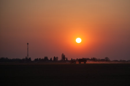 Red sunset over the field. Beautiful sunset in nature. Rural nature at sunset. Red sunset landscapeの写真素材