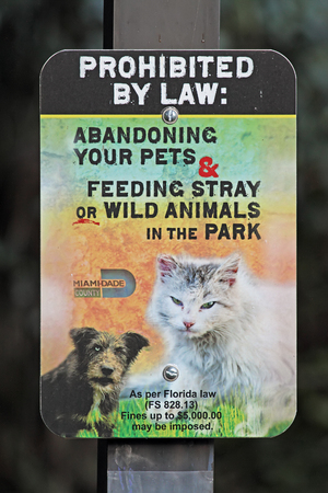 A sign in Miami's A.D. "Doug" Barnes Park warns against abandoning pets or feeding animals in the parkの写真素材