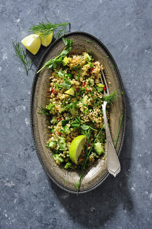 Groat salad tabbouleh with fresh cucumber, avocado and herbsの写真素材