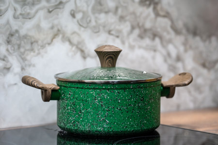 Green cooking pot on the gas stove in the kitchen. Shallow depth of field