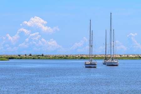Three sailing boats anchoring near beach coastlineの写真素材