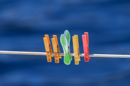 Clothespins on rope before blue backgroundの写真素材