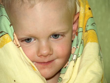 Closeup of boy under quiltの写真素材