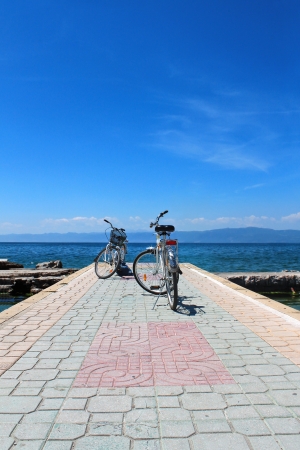 Two white bicycles with the lake in the backgroundの写真素材