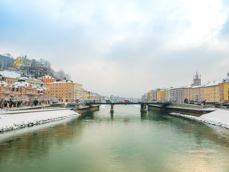 Landscape view winter snow season blue sky green river bridge in Salzburg.の写真素材