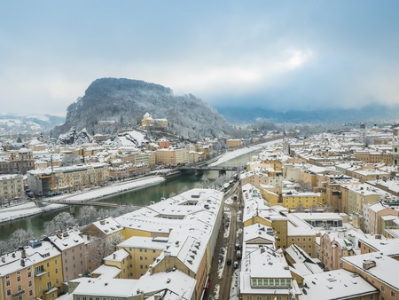 Beautiful panoramic view of Salzburg skyline with river Salzach in winter season snow , Austriaの写真素材