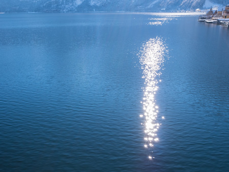 The reflection of light on water at blue lake hallstatt austriaの写真素材