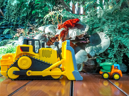 Children baby toys tractor and truck on wooden floor in the beautiful garden forest playground
