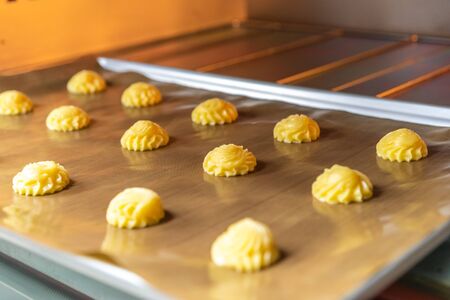 Bakery baker preparing bread cooking in the oven.Bakery close up holding a peel with freshly baked.Activity during quarantine home with family together.の写真素材