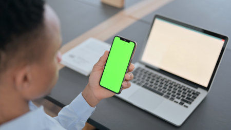 African Man Holding Smartphone with Green Chroma Key Screen