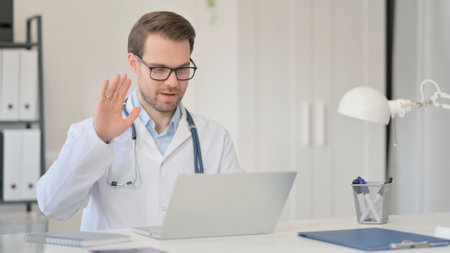 Male Doctor with Laptop having Headache in Clinicの写真素材