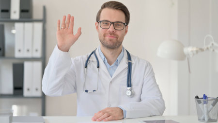 Male Doctor Waving hand for Video Chatの写真素材