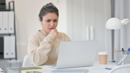 Young Indian Woman with Laptop Coughingの写真素材